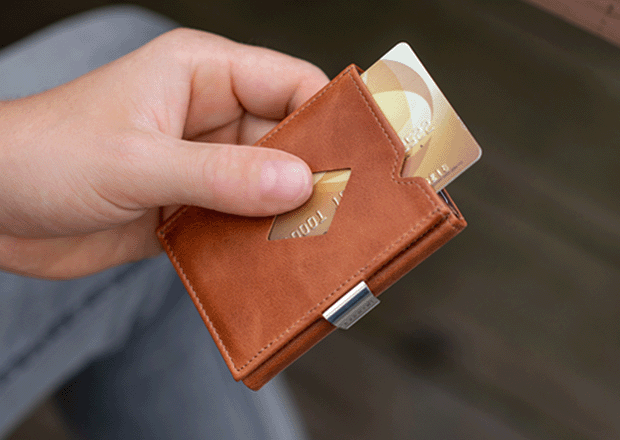 Hånd som skyver kort ut av lommebokens skyvevindu for rask tilgang
